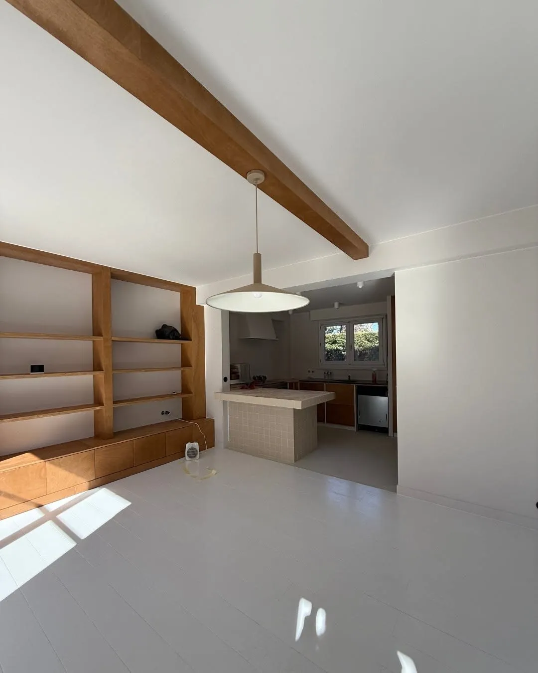 Living room with a bespoke bookcase and open-plan kitchen